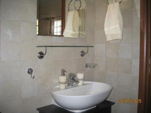 a bathroom with a white sink and a mirror at Forest Breeze-1 - JM Rentals in Stení Dhírfios