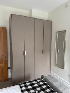 a bedroom with white cabinets and a checkered floor at Unit 3 Modern Self Contained Apartment in Cobh