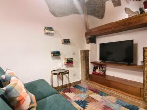 a living room with a couch and a flat screen tv at La Casina di Rosina in Sacrofano