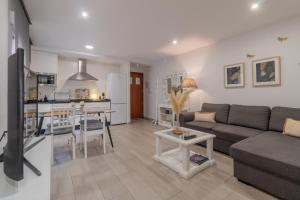 ein Wohnzimmer und eine Küche mit einer Couch und einem Tisch in der Unterkunft El Refugio de La Corredera & Parking Incluido in Córdoba