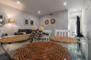 ein Wohnzimmer mit einem Glastisch und 2 Stühlen in der Unterkunft El Refugio de La Corredera & Parking Incluido in Córdoba