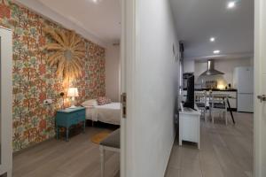 ein Schlafzimmer und ein Wohnzimmer mit einem Bett und einer Küche in der Unterkunft El Refugio de La Corredera & Parking Incluido in Córdoba