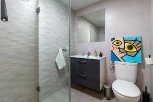 ein Badezimmer mit Toilette, Waschbecken und Spiegel in der Unterkunft El Refugio de La Corredera & Parking Incluido in Córdoba + 31 Fotos