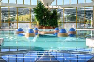 a pool with blue spheres in a building at Park Inn by Radisson Sarvar Resort & Spa - All Inclusive in Sárvár +71 photos