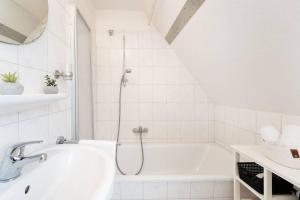 Un baño blanco con bañera y lavabo. en Vadersdorf-6c, en Vadersdorf 10 fotos más