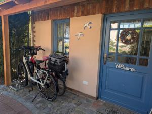 two bikes parked on the side of a house with a door at Märchengarten Fischer un sin Fru in Putbus