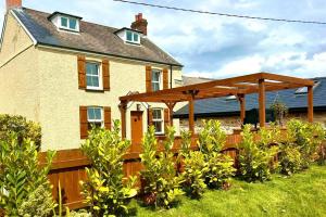 une pergola en bois devant une maison dans l'établissement 3 Bed in Rhossili oc-f33389, à Rhossili