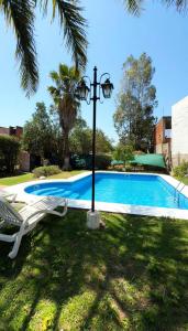 a swimming pool with a light pole and a chair and a lamp at Tanti in Reyes