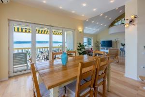 een eetkamer en woonkamer met een tafel en stoelen bij Apartments Neno in Crikvenica