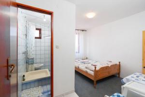a bedroom with a bed and a tub and a sink at Rooms Mat in Vir