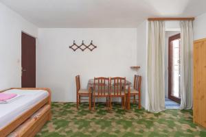 a bedroom with a bed and a table and chairs at Rooms Mat in Vir