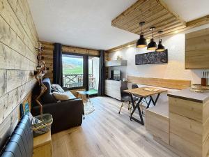 a living room and kitchen with a couch and a table at Les Tanières de Montgenèvre - Studio Dama - neuf 4p avec terrasse vue imprenable in Montgenèvre
