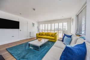 ein Wohnzimmer mit Sofa und Fernseher in der Unterkunft Sundowner - West Wittering in East Wittering