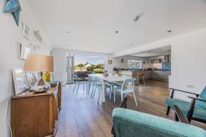 ein Esszimmer und ein Wohnzimmer mit Tisch und Stühlen in der Unterkunft Sundowner - West Wittering in East Wittering