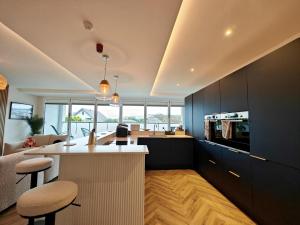 una cocina con armarios negros y una isla de cocina con taburetes en 5 Bed in Shanklin oc-s33401, en Shanklin