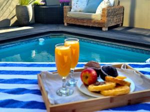 a tray of food and drinks next to a swimming pool at 9 on Winkle Boutique Guesthouse in Cape Town