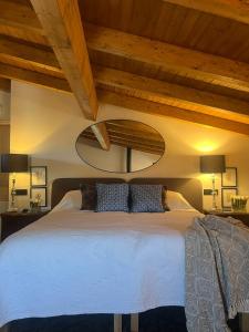 a bedroom with a white bed with a wooden ceiling at Casa Rural La Real de Guadalupe in Guadalupe