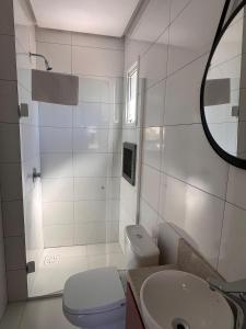 a bathroom with a toilet and a sink and a mirror at Charmoso apê, perto da faculdade e da gastronomia in Passo Fundo