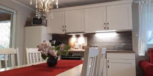 a kitchen with white cabinets and a vase of flowers on a table at Märchengarten Hänsel und Gretel in Putbus +21 photos
