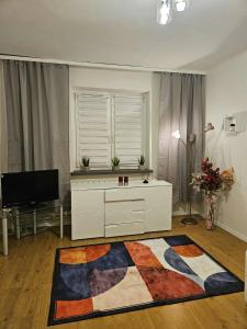 un soggiorno con cassettiera bianca e finestra di Apartament Zielony Zakątek a Dąbrowa Górnicza