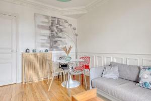 un soggiorno con un divano e un tavolo di L'Haussmannien 2BR aux portes Paris - 2 min Métro a Clichy