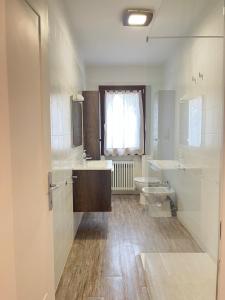 a bathroom with two sinks and a toilet and a window at Da Gas e Nana in Peseggia