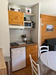 a small kitchen with a sink and a microwave at Orelle 3 Vallées - SPA&PISCINE in Orelle