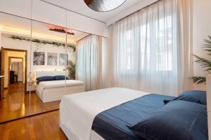 a bedroom with a large white bed and a mirror at Appartamento 3 in Viareggio