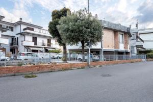 a tree and a fence in front of a building at Appartamento 3 in Viareggio