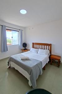 a bedroom with a large bed and a window at Suíte casal in Arraial do Cabo