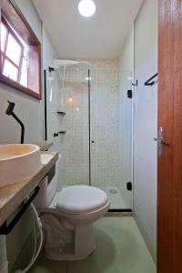 a bathroom with a toilet and a sink and a shower at Suíte casal in Arraial do Cabo +92 photos