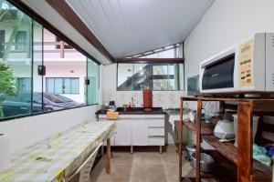 a room with a kitchen with a sink and a microwave at Suíte casal in Arraial do Cabo