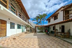 a courtyard of a house with a palm tree at Suíte casal in Arraial do Cabo