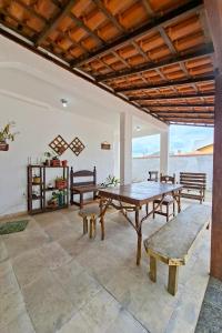 a dining room with a table and benches at Suíte casal in Arraial do Cabo
