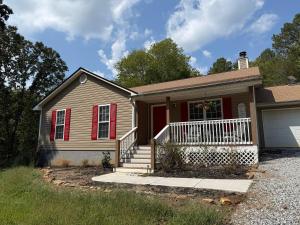a house with a red door and a garage at The Nest - A Getaway with a Huge Game Room in Ranger