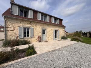 a stone house with a patio in front of it at Le Sablon Blanc - 6pers - Rêve au Mans in Sargé Les Le Mans 