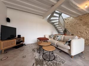 a living room with a couch and a tv at Le Sablon Blanc - 6pers - Rêve au Mans in Sargé Les Le Mans 