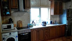 uma cozinha com um lavatório, um fogão e uma janela em Cottage Ozerniy em Lazeshchyna