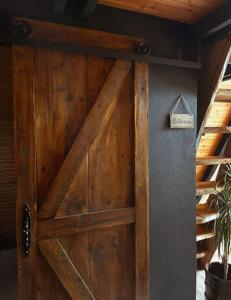 una porta di legno con un cartello su un muro di Cottage fairy a Dubrave Gornje