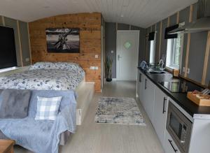 a small bedroom with a bed and a kitchen at Tranquil Cabin Retreat- Sleeps 2 Parking in Welshpool