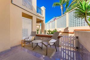 - un balcon avec deux chaises et une table dans l'établissement Yucca Park 1 Bed Apartment, à Adeje