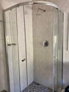 a shower with a glass door in a bathroom at Studio near Airport City Centre - 2317 in Highlands