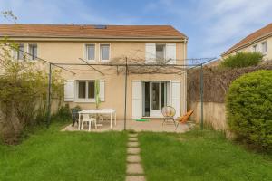 a house with a table and chairs in the yard at Roissy CDG, private room 4 in Roissy-en-France