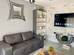 a living room with a couch and a flat screen tv at Studio near Airport City Centre - 2317 in Highlands