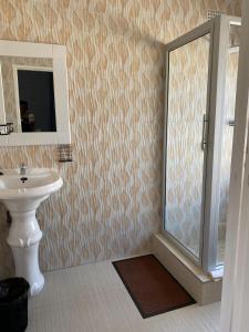 ein Badezimmer mit Dusche, Waschbecken und Spiegel in der Unterkunft Executive studio apartment near the airport - 2320 in Highlands