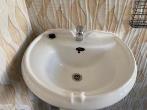 ein weißes Waschbecken im Bad mit einer Wand in der Unterkunft Executive studio apartment near the airport - 2320 in Highlands + 29 Fotos