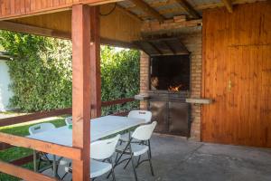 a table and chairs on a patio with a fireplace at Vila Dom Drina Zatvoreni Bazen in Bajina Bašta