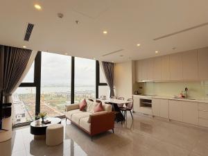 a living room with a couch and a table in a kitchen at ICON40 Ha Long Luxury Apart in Ha Long