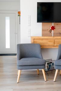 a living room with two chairs and a tv at Corner 28 in Oberkirch