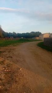 an empty dirt road with a playground in the distance at Love room in Paizay-le-Chapt +8 photos